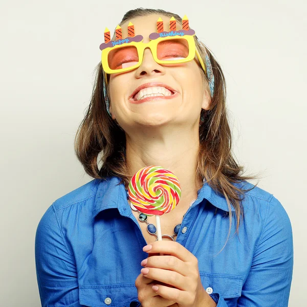 Woman wearing big sunglasses holding lollipop — Stock Photo, Image