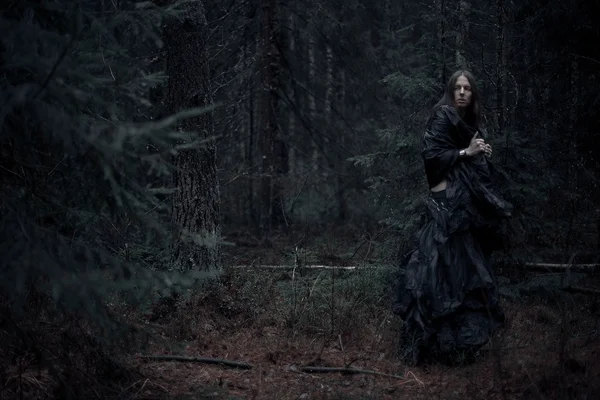 Hombre de pelo largo en el bosque oscuro —  Fotos de Stock