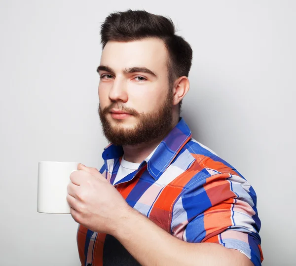 Jeune homme barbu avec une tasse de café — Photo