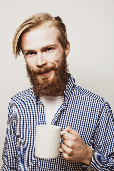 Joven barbudo con una taza de café — Foto de Stock