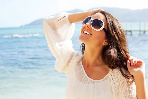 Glückliche Frau im weißen Sommerkleid am Strand. — Stockfoto