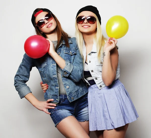 Chicas hipster sonriendo y sosteniendo globos de colores — Foto de Stock
