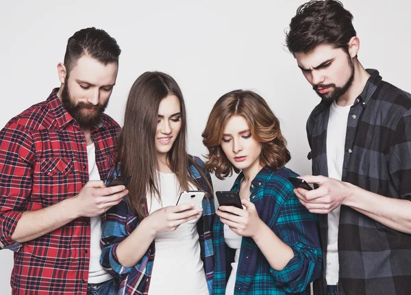 Young people  looking at their phones — Stock Photo, Image