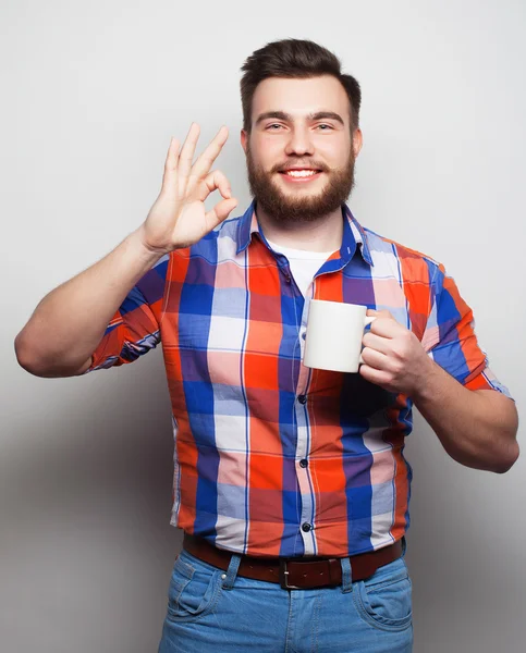 Mladý vousatý muž s šálkem kávy — Stock fotografie