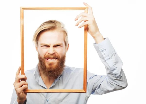 Hombre joven sosteniendo marco de imagen — Foto de Stock