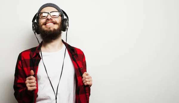 Nuori parrakas mies kuuntelemassa musiikkia — kuvapankkivalokuva