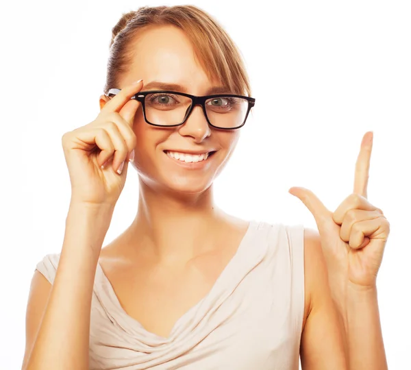 Kvinna som bär glasögon pekar uppåt — Stockfoto