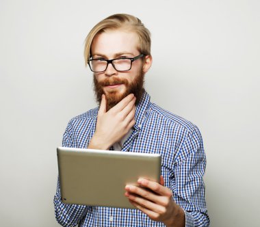 Genç adam tablet bilgisayar kullanıyor.