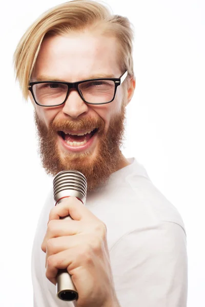 Joven con una barba sosteniendo un micrófono — Foto de Stock