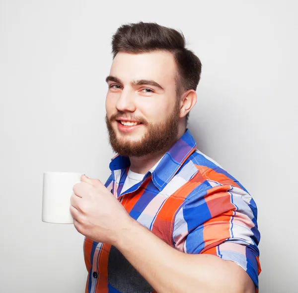 Giovane uomo barbuto con una tazza di caffè — Foto Stock
