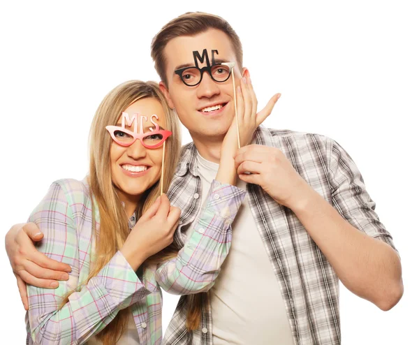 Encantador casal segurando óculos de festa no pau — Fotografia de Stock