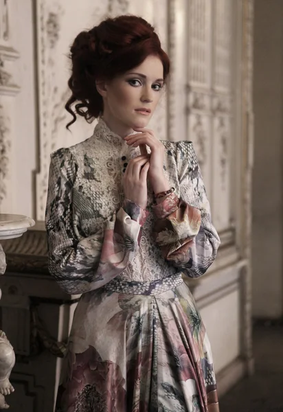 Mooie vrouw staat in de paleis kamer. — Stockfoto