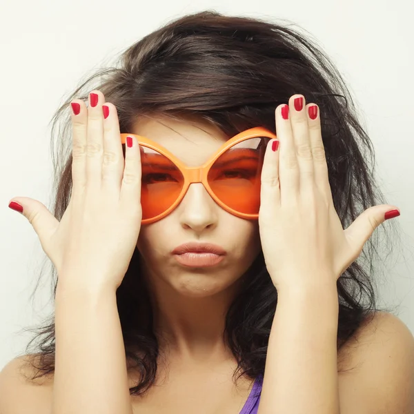 Jeune femme avec de grandes lunettes de soleil orange — Photo