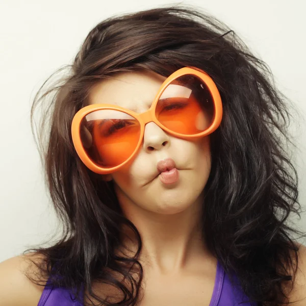 Mujer joven con grandes gafas de sol naranjas — Foto de Stock