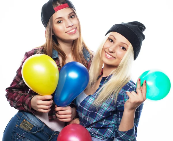 Hipster-Mädchen lächeln und halten bunte Luftballons in der Hand — Stockfoto