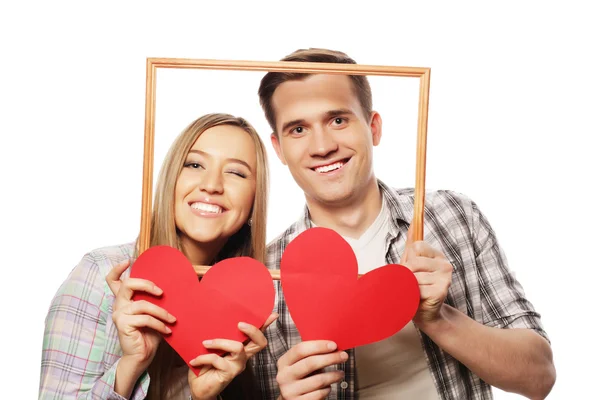 Encantador casal segurando quadro e corações vermelhos — Fotografia de Stock