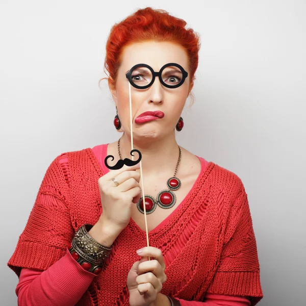 Young woman holding mustache and glasses — Stock Photo, Image