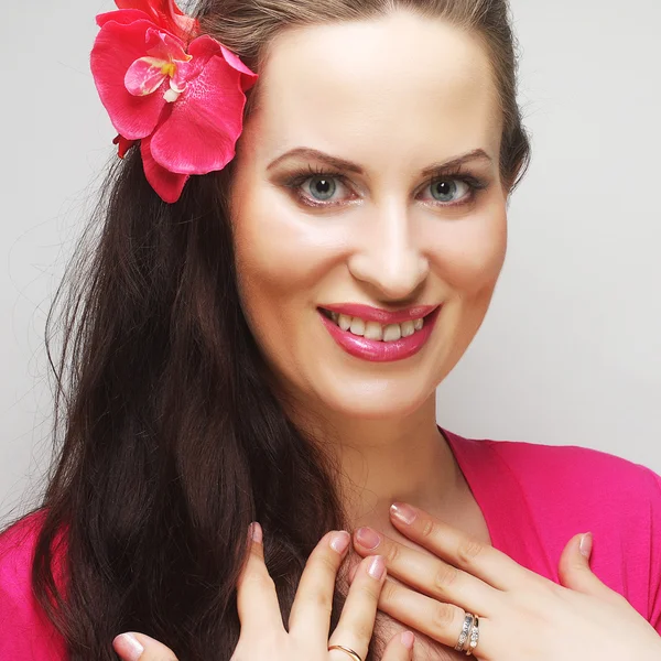 Glückliche Frau mit rosa Blume im Haar — Stockfoto