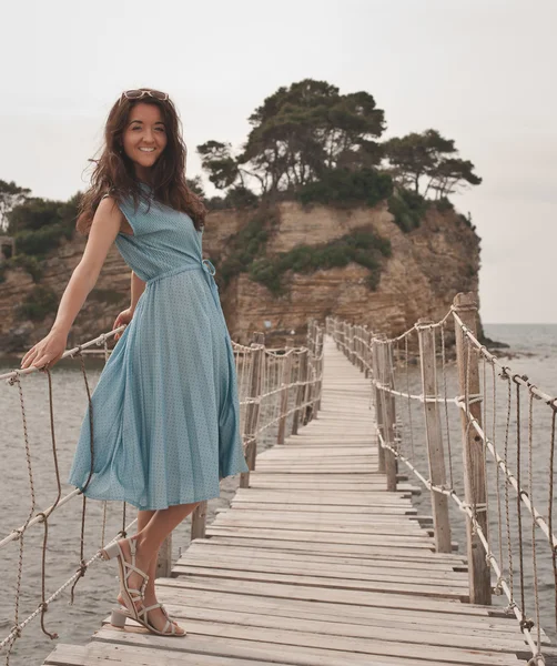 Jovem mulher feliz na ponte perto do mar — Fotografia de Stock