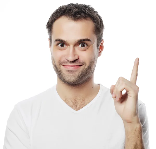 Joven sonriente feliz hombre muestra algo —  Fotos de Stock