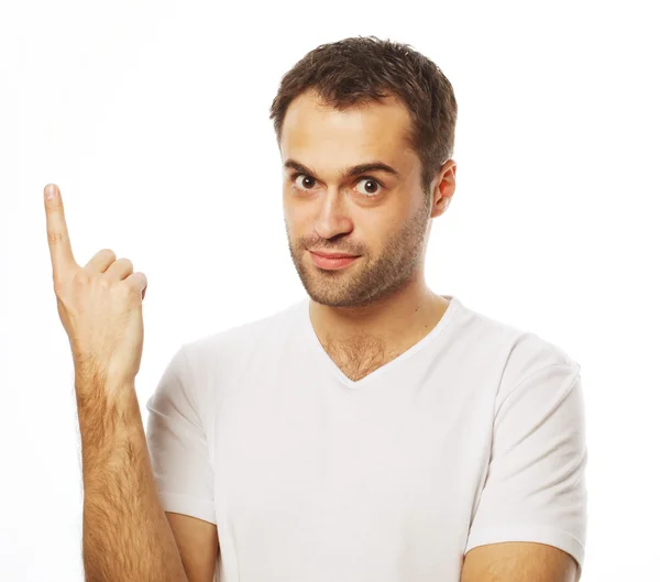 Joven sonriente feliz hombre muestra algo — Foto de Stock