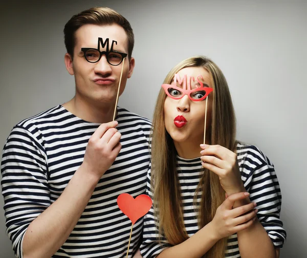 Couple holding party glasses and hat on sticks — Stock Photo, Image