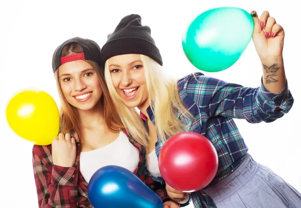 Chicas hipster sonriendo y sosteniendo globos de colores — Foto de Stock