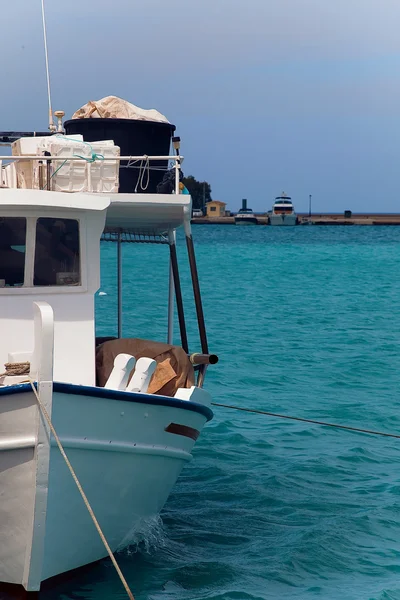 Um pequeno barco de pesca amarrado no porto em um belo mar — Fotografia de Stock