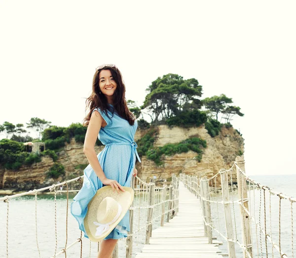 Junge Frau mit Sommerhut posiert auf der Brücke — Stockfoto