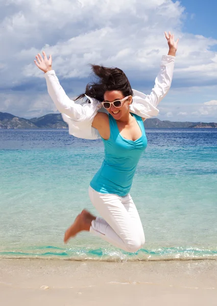 Happy girl jumping on the beach — Stock Photo, Image