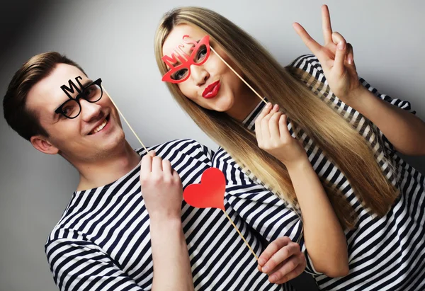 Couple holding party glasses and hat on sticks — Stock Photo, Image