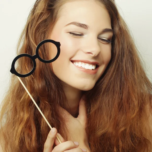 Mujeres jóvenes juguetonas sosteniendo unas gafas de fiesta . — Foto de Stock