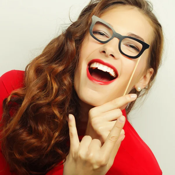 Mujeres jóvenes juguetonas sosteniendo unas gafas de fiesta . — Foto de Stock