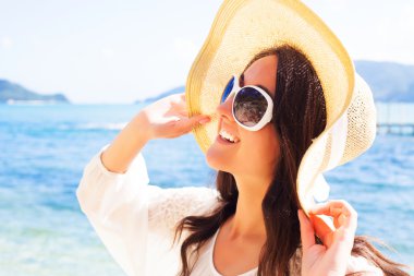 Sahilde şapkalı mutlu kadın