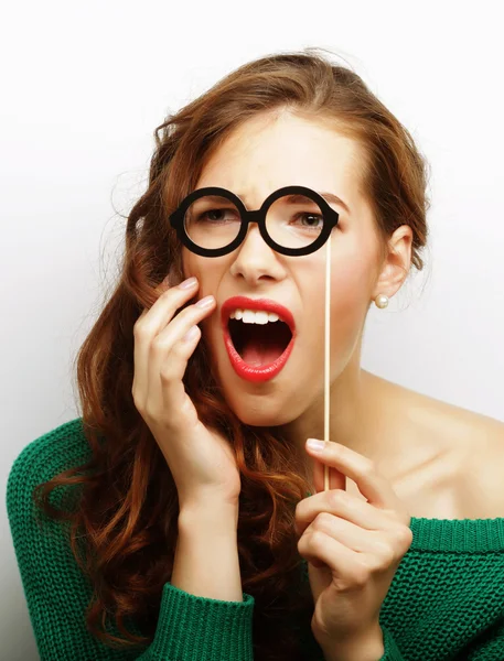 Jovencita juguetona sosteniendo unas gafas de fiesta . —  Fotos de Stock