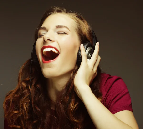 Mujer joven con auriculares escuchando música — Foto de Stock