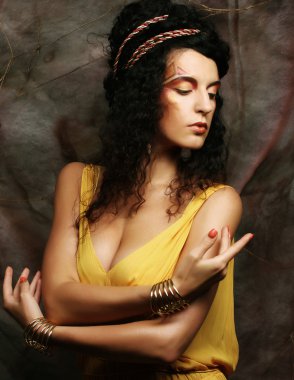 Sarı gece elbisesi giymiş esmer kadın