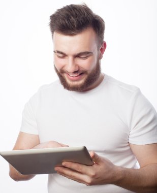 Genç adam tablet bilgisayar kullanıyor.