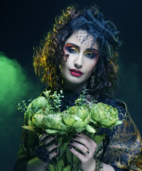 Woman with brigt visage holding big green flowers — Stock Photo, Image