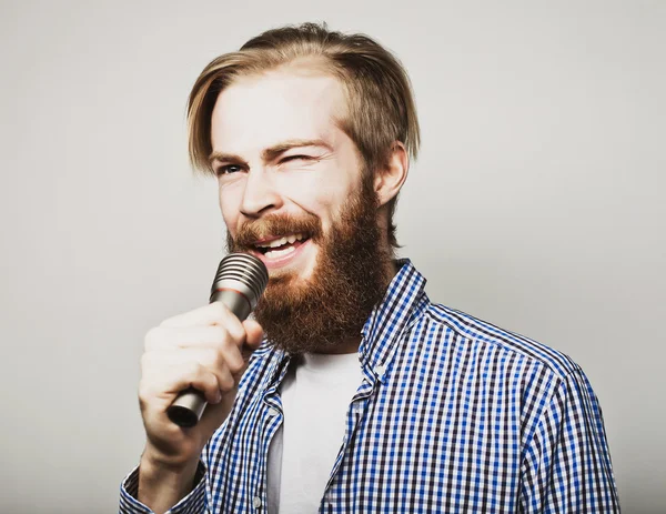 Joven sosteniendo un micrófono y cantando —  Fotos de Stock