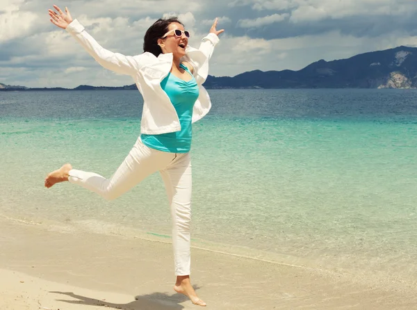 Glückliches Mädchen springt auf den Strand — Stockfoto