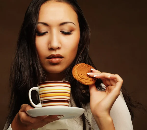 Asian woman with coffee and cookies. — Stock Photo, Image