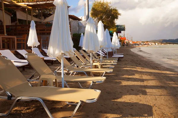 Ξαπλώστρες με ομπρέλες στην όμορφη παραλία — Φωτογραφία Αρχείου