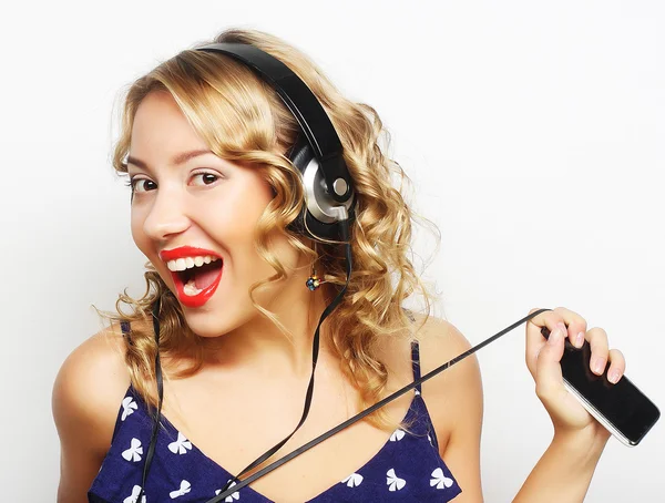 Jovem mulher feliz com fones de ouvido ouvindo música — Fotografia de Stock