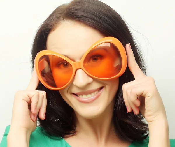 Jeune femme heureuse avec de grandes lunettes de soleil orange — Photo