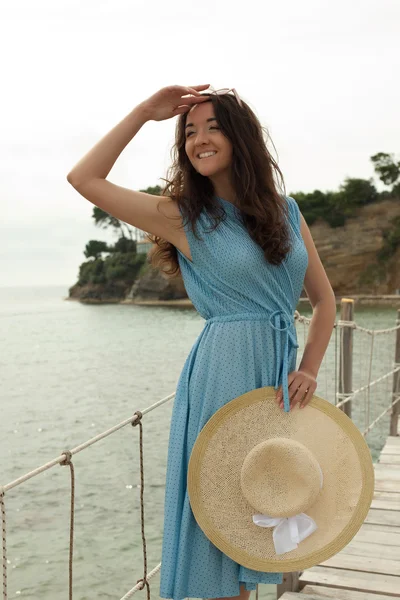 Ung kvinna med sommaren hatt poserar på bron — Stockfoto