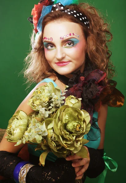 Woman with brigt visage holding big green flowers — Stock Photo, Image
