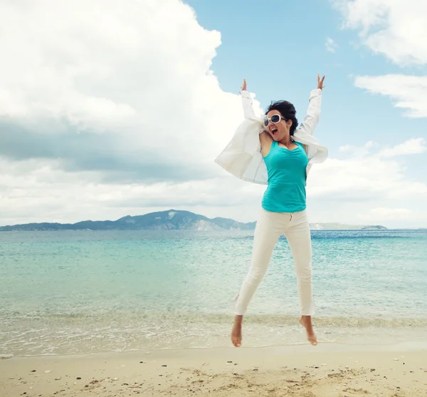 Chica feliz saltando en la playa — Foto de Stock