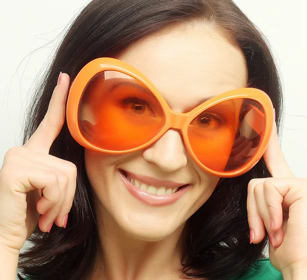 Jeune femme heureuse avec de grandes lunettes de soleil orange — Photo