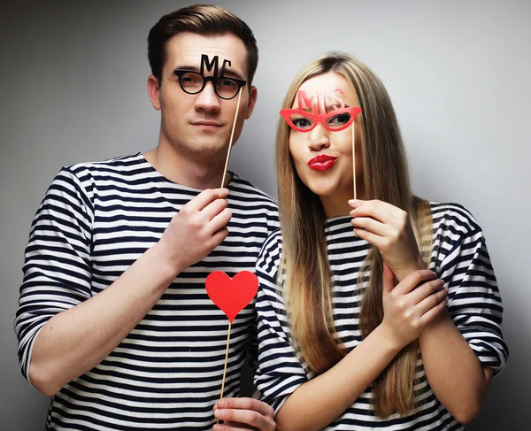 Couple holding party glasses and hat on sticks — Stock Photo, Image